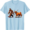 Bigfoot And Scottish Highland Cow Walking Humor Bigfoot Takes Scottish Highland Cow for a Walk T-Shirt - Baby Blue